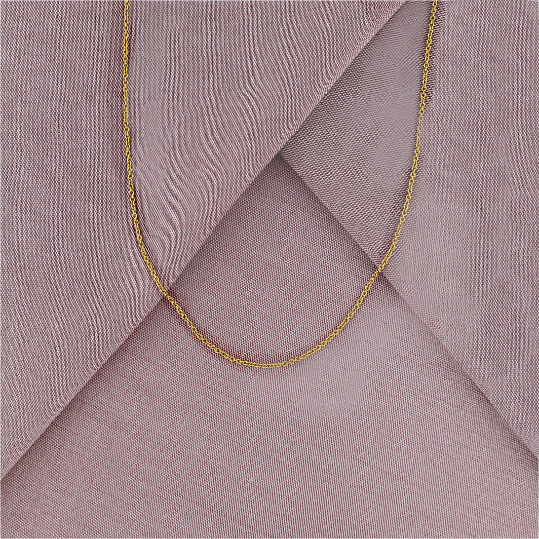 A close-up of a 18 karat gold chain necklace displayed on a purple cloth.