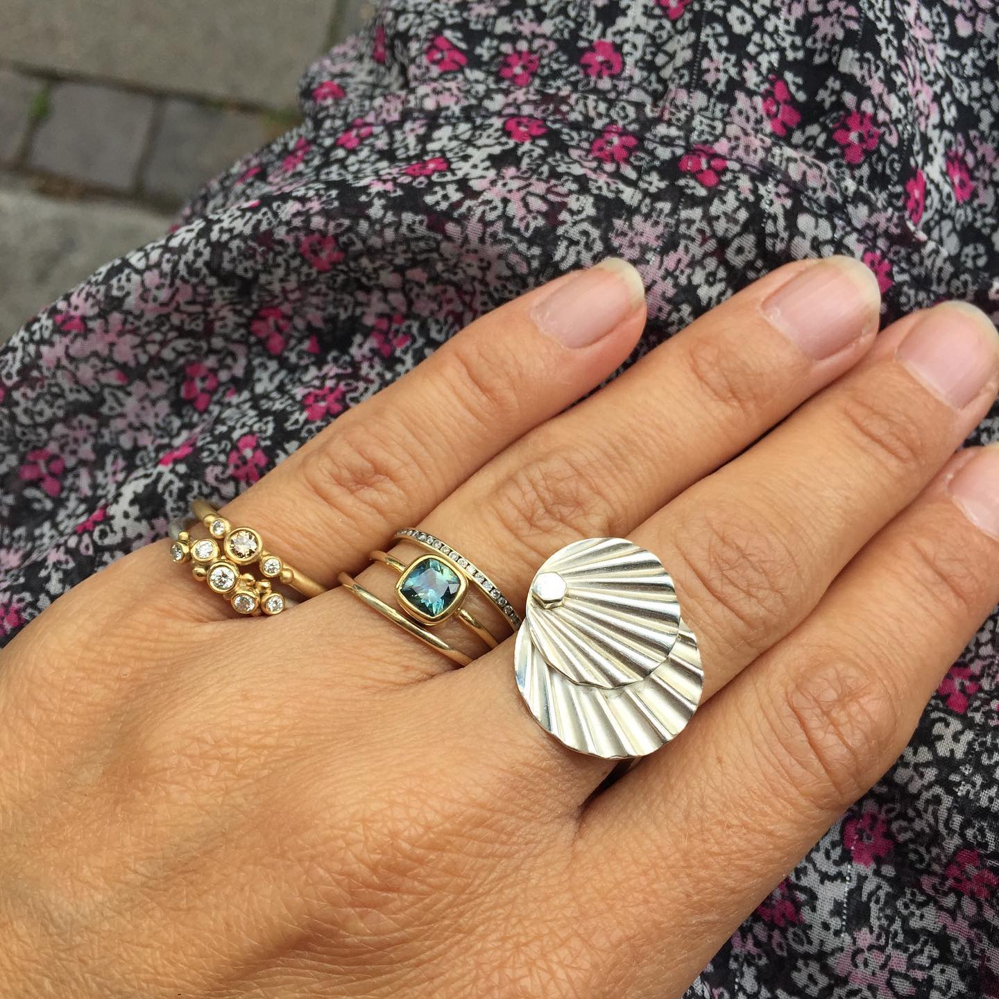 A 925 sterling silver art deco ring, with a square ringprofile and a wavy top. Styled with other gold rings with diamonds and other gemstones.