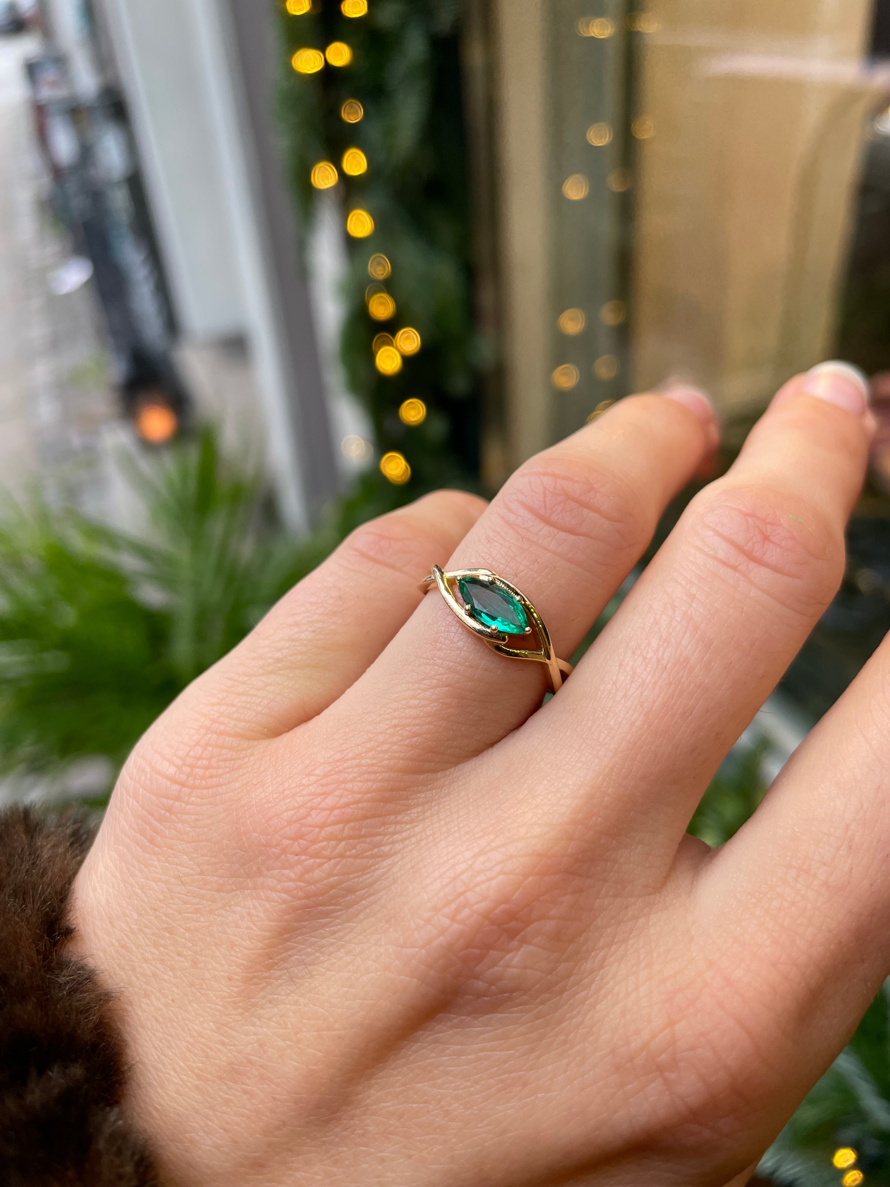 Custom made engagement ring. A gold ring with an oval, green sapphire.