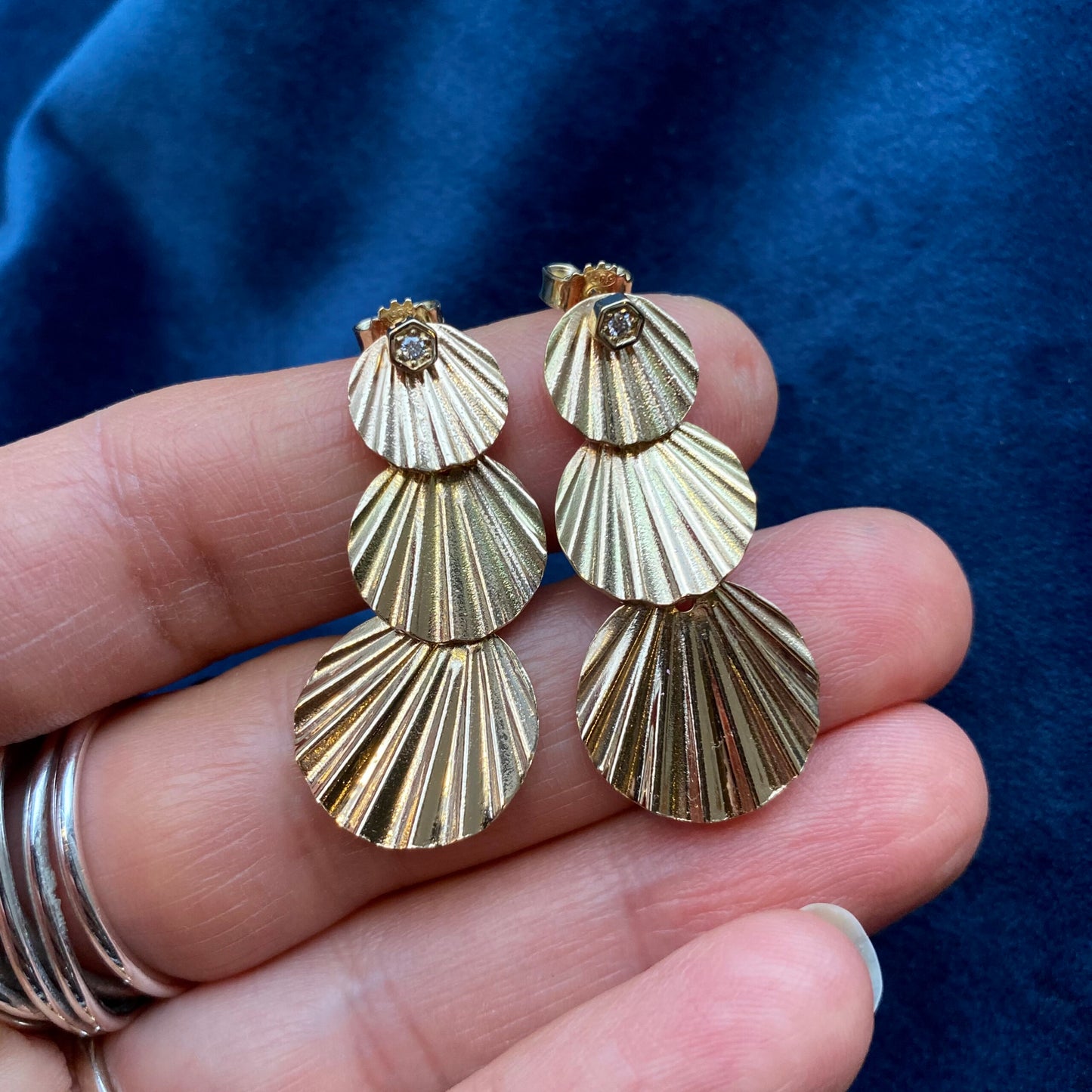 Art deco inspired earrings. In gold or silver, with three round pieces dangling from a diamond earring stud. 